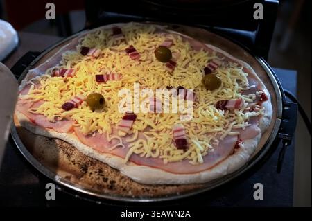 Pizza maison préparée pour la cuisson au four à pizza Banque D'Images