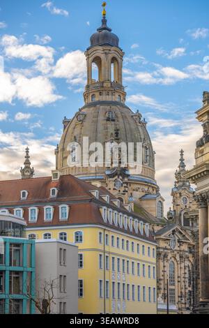 La Frauenkirche de Dresde présente son dôme proéminent contre un ciel bleu. Les bâtiments voisins ajoutent au paysage architectural. La scène capture une journée typique en Allemagne. Banque D'Images