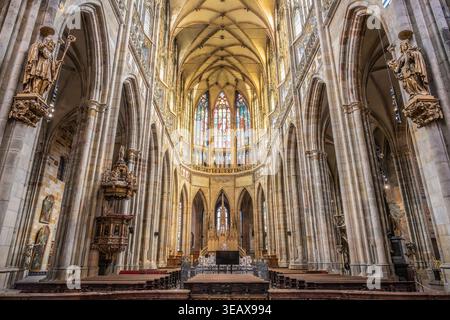 Les visiteurs explorent l'intérieur de la cathédrale de la célèbre Vitus au château de Prague en République tchèque. Les grandes arches et les vitraux créent une atmosphère unique pour tous. Banque D'Images