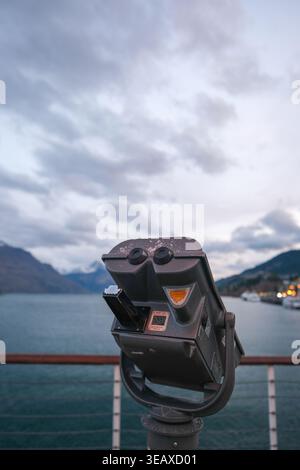 Visionneuse jumelle surplombant les montagnes enneigées et le lac Wakatipu depuis Queenstown main Town Pier. Banque D'Images