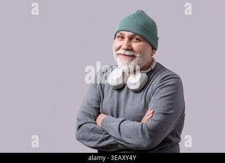 Portrait d'homme barbu mature souriant écoutant de la musique dans des écouteurs. Concept technologique, fun Banque D'Images