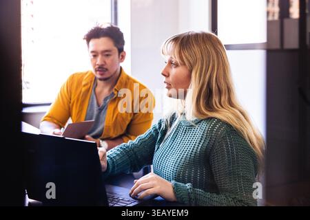 Équipe multiraciale travaillant sur ordinateur au bureau Banque D'Images