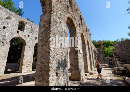 Touriste visitant les ruines de pierre antiques de la Grande Basilique dans le site archéologique du parc national de Butrint en Albanie Banque D'Images