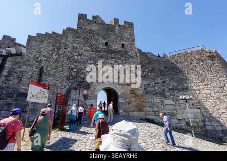 Les touristes entrent dans le château historique de Berat par une passerelle en pierre voûtée dans la citadelle de Berat, en Albanie Banque D'Images