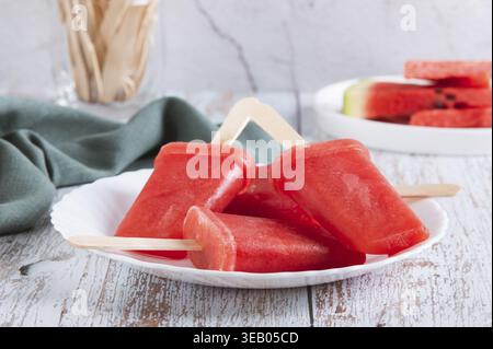 Pastèque popsicles sur des bâtons de bois sur une assiette sur une table Banque D'Images