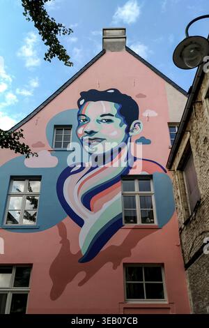 Bruxelles, Belgique - 29 août 2018 - murale colorée sur un bâtiment urbain mettant en vedette un jeune homme souriant Banque D'Images