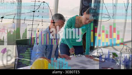 Penché dans la salle de réunion, femme en chemise bleue pointant, homme en plan d'écriture sur le dessus sarcelle, casque Banque D'Images