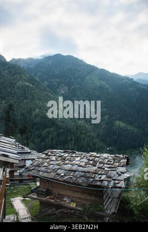 Une pittoresque maison traditionnelle en bois nichée dans un paysage montagneux verdoyant près de Jibhi, Kheerganga, Manali, Inde. La maison dispose d'un rusti Banque D'Images