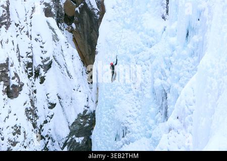 Grimpeur ascendant cascade gelée dans le paysage d'hiver Banque D'Images