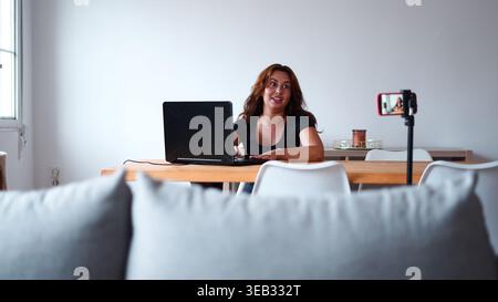 Femme créant du contenu en ligne engageant, vidéo pour les médias sociaux, travaillant à domicile Banque D'Images