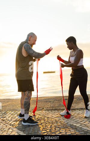 Mains enveloppantes de couple diversifiées pour l'entraînement de boxe en plein air Banque D'Images