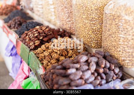 Noix, dattes et pistaches exposés au bazar Siab à Samarcande. Fruits secs et noix en abondance dans un étal traditionnel d'Asie centrale, Banque D'Images