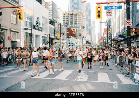 Toronto, Canada - 29 juin 2025 : contingent de marche avec drapeaux arc-en-ciel Banque D'Images