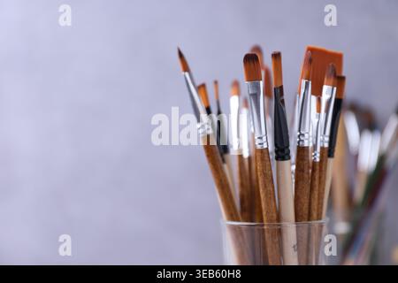 Pinceaux en verre sur fond flou, gros plan. Espace pour le texte Banque D'Images