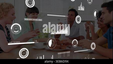 Parler cinq collègues dans le bureau décontracté porter partageant des pâtisseries, des tasses à la table en bois avec des superpositions AR Banque D'Images