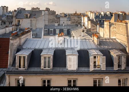 Les toits de Paris au coucher du soleil vus depuis un appartement du 2ème arrondissement, Paris, France, présentant une architecture haussmannienne classique et des toits en zinc Banque D'Images