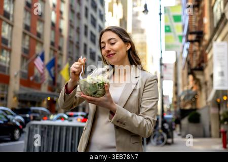 Femme professionnelle profitant d'un déjeuner salade fraîche saine à manhattan Banque D'Images