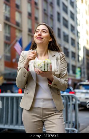 Femme d'affaires appréciant un déjeuner salade sain sur manhattan Street Banque D'Images