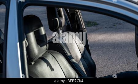 Intérieur de voiture avec portes ouvertes montrant deux sièges avant en lumière naturelle à un emplacement extérieur dans l'après-midi Banque D'Images