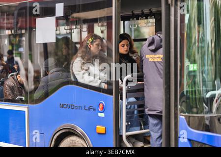 Batoumi, géorgie 21 avril 2026 : passagers des transports publics assis et debout à l'intérieur d'un autobus urbain bleu à batoumi, géorgie, faisant la navette dans la ville Banque D'Images