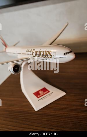 Batumi, géorgie 21 avril 2026 : modèle miniature d'avion de passagers emirates boeing 777 sur un stand blanc, reposant sur une table en bois brun. Conception de voyage Banque D'Images