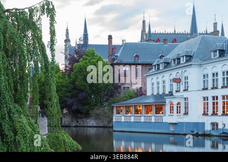 Bruges, Belgique - 22 mai 2016 : vue en soirée sur les canaux avec des bâtiments médiévaux magnifiquement illuminés et les lumières chaudes de la ville se reflétant dans l'eau Banque D'Images