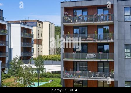 Complexe résidentiel moderne comprenant des bâtiments contemporains à plusieurs étages avec balcons. Le bâtiment au premier plan présente des panneaux de façade gris Banque D'Images
