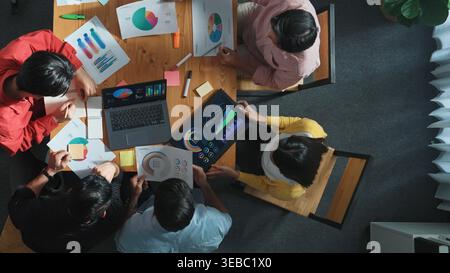Vue de dessus de l'équipe commerciale travaillant ensemble tout en parlant de graphique financier. Gros plan d'une équipe marketing compétente partageant des idées et examinant les stocks Banque D'Images