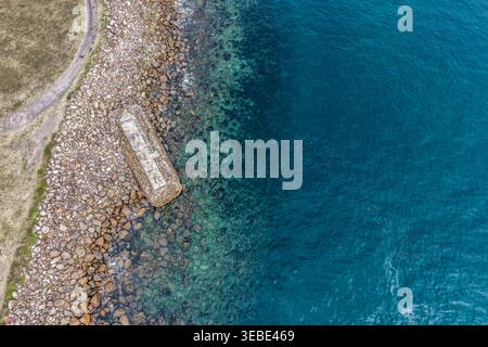 Vue aérienne du site de torpille de la seconde Guerre mondiale à Tomaree Head en Nouvelle-Galles du Sud, Australie, où la côte rocheuse accidentée rencontre l'océan turquoise. Scen Banque D'Images