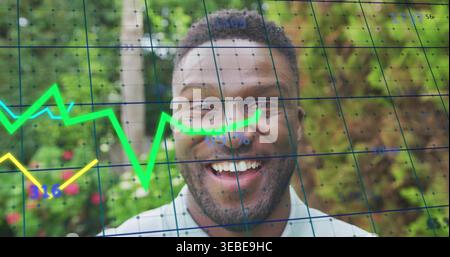 Homme mi-adulte souriant portant une chemise à col léger face à la caméra dans le jardin, avec superposition de graphiques de données Banque D'Images