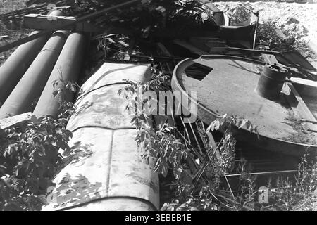 Sloviansk, région de Donetsk, années 1980 Photographie d'archives prise sur le territoire de l'usine AIZ. La scène capture un gros plan détaillé des extrémités de nombreux tuyaux en métal lourd empilés ensemble à l'extérieur dans une aire de stockage d'usine industrielle ou dans une zone de rebut. L'image détaille méticuleusement les textures authentiques, l'ingénierie structurelle et l'atmosphère générale du cadre industriel. Ce document historique préserve magnifiquement la vie soviétique quotidienne, le patrimoine industriel et l'environnement de fabrication dans le Donbass paisible. Banque D'Images