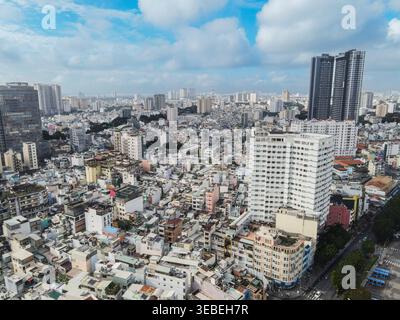 Vue aérienne de l'horizon urbain dense avec un mélange de gratte-ciel modernes et de bâtiments résidentiels traditionnels sous un ciel bleu avec des nuages blancs à Ho Banque D'Images