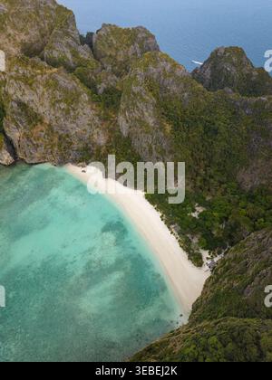 Vue aérienne des îles Phi Phi avec une plage de sable blanc et une eau turquoise entourée d'imposantes falaises calcaires et d'une végétation luxuriante à Mueang Kr Banque D'Images