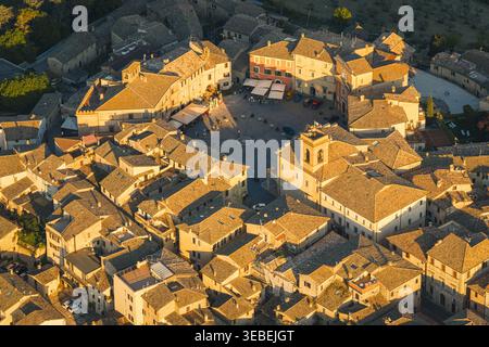 Vue aérienne du centre historique avec la Piazza del Comune circulaire entourée de bâtiments en pierre et de toits carrelés pendant l'heure dorée à LUN Banque D'Images