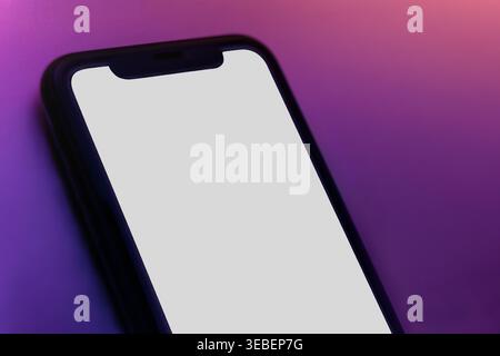 Gros plan du téléphone mobile sur fond dégradé lumineux, maquette minimaliste moderne pour la conception de la présentation de l'application. Smartphone avec écran vierge. Copier l'espace Banque D'Images