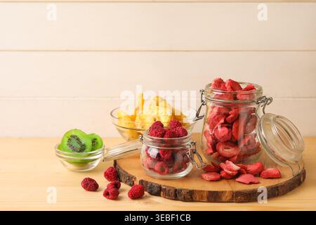 Bols et pots de différents fruits déshydratés et baies sur table en bois Banque D'Images