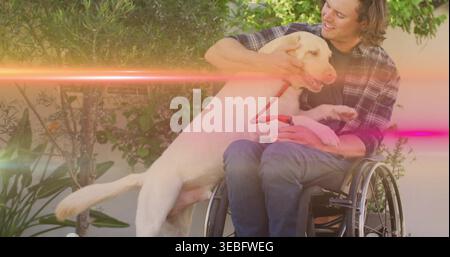 Homme souriant en chemise à carreaux et jeans tenant un grand chien à fourrure légère en fauteuil roulant manuel, laisse rouge Banque D'Images