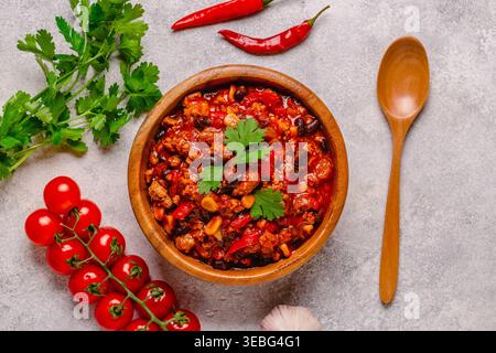 Chili Con Carne dans un bol sur fond sombre. Cuisine mexicaine. Vue de dessus Banque D'Images