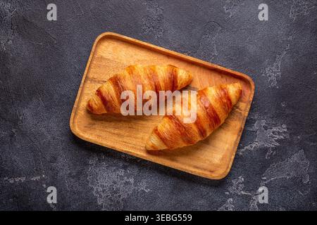Croissant français. Croissants fraîchement cuits sur un fond de pierre sombre. Banque D'Images