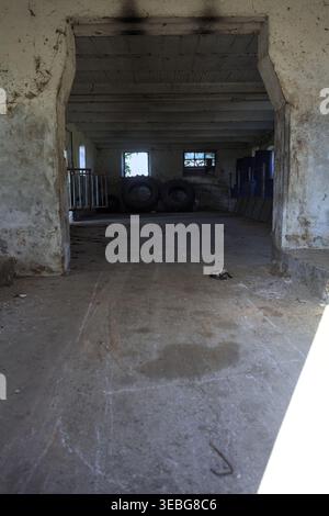 Grange vide dans un manoir abandonné avec un rayon de soleil entrant dans la chambre, dans la campagne italienne Banque D'Images