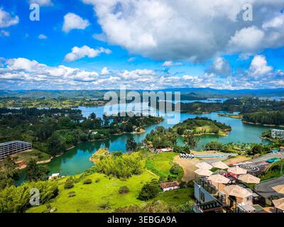 Vue panoramique sur le réservoir de Peñol-Guatapé avec un paysage lacustre tropical animé avec des îles, des collines verdoyantes et des montagnes lointaines sous-jacentes Banque D'Images