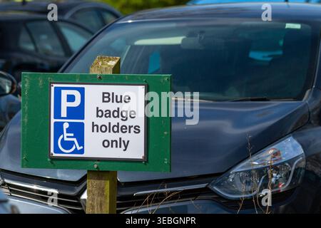 Le panneau « détenteurs d'un badge bleu uniquement » indique une aire de stationnement réservée aux personnes handicapées. Banque D'Images