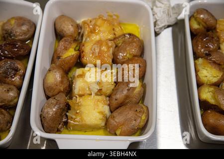 « Bacalhau à lagareiro » portugais avec pommes de terre écrasées et oignons servis sur un plateau buffet prêt à servir. Banque D'Images