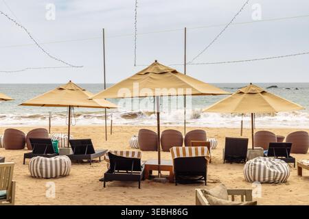 Salon accueillant en bord de mer avec sièges confortables et parasols ouverts, parfait pour une escapade relaxante et luxueuse en bord de mer. Île de Sri Lanka en Banque D'Images