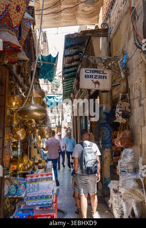 Le Caire, Égypte - 20 avril 2026 : vue du bazar de Khan el-Khalili avec des gens marchant dans une ruelle étroite bordée de lampes en laiton traditionnelles et de souvenirs Banque D'Images