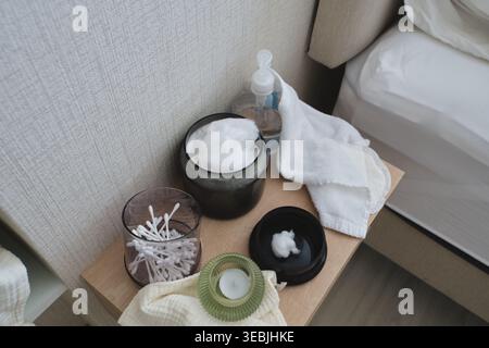 Des produits essentiels au bien-être disposés sur une table de nuit pour un rituel de soin relaxant Banque D'Images