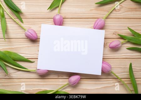 Maquette de carte de voeux vierge avec tulipes roses sur fond en bois plat Banque D'Images