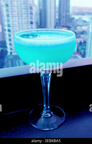 Cocktail pop art bleu aqua surréaliste sur la table du bar sur le toit Banque D'Images