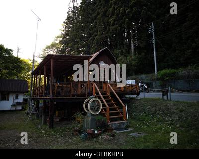 ANNAKA, JAPON - 25 avril 2026 : vue extérieure d'une cabane rustique en bois et d'une terrasse nichée dans les montagnes verdoyantes près du sentier Abt-no-Michi. Banque D'Images