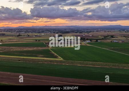Vue aérienne du coucher de soleil coloré sur la rivière Morpeth et les terres agricoles environnantes en Nouvelle-Galles du Sud, Australie. Paysage rural pittoresque montrant un ciel vibrant Banque D'Images